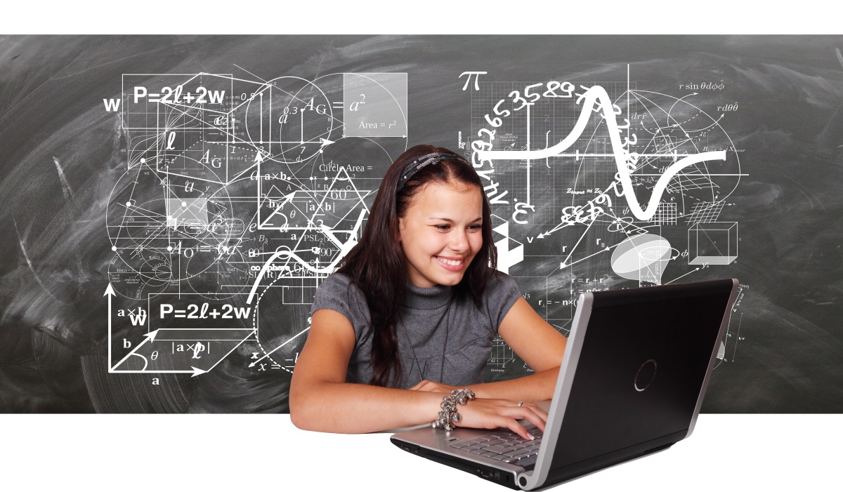 Student on laptop in front of chalkboard